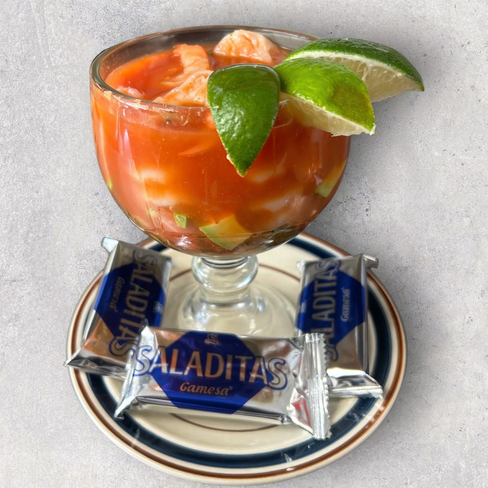 Mexican shrimp cocktail with avocado and lime, served with Saliditas crackers on a plate.